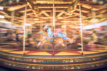 Motion blurr of vintage carousel horse of amusement ride on merry-go-round carousel. Amusement...