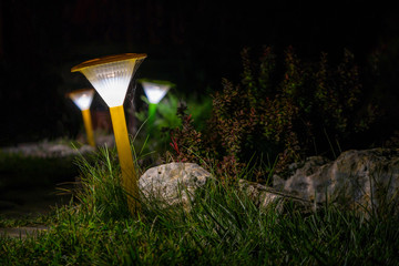Decorative small yellow solar garden lantern. solar powered lamp. summer night in garden