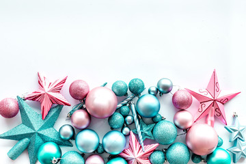 Christmas decoration pattern. Pink and blue stars and balls near pine branches on white background top view copyspace