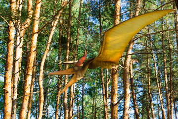 The figure of a dinosaur hovering under the trees in the forest. © Vladimir