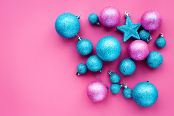 Christmas toys. Pink and blue balls and stars on pink background top view copyspace