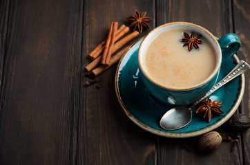 Indian masala chai tea. Spiced tea with milk on dark  wooden background, selective focus, copy space.