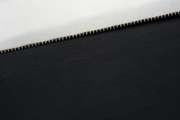 Hand saw close up on dar wooden background