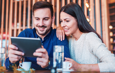 Young couple having fun with tablet. Dating, relationships, love, romance, lifestyle, technology