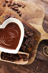 Chocolate cream melted and chocolate pieces on wooden table