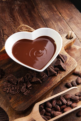 Chocolate cream melted and chocolate pieces on wooden table