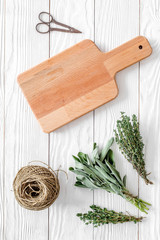 flat lay with fresh herbs and greenery for drying and making spices set on white wooden kitchen background mock-up