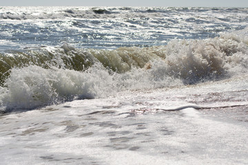 Waves on a sea sand beach on a sunny day