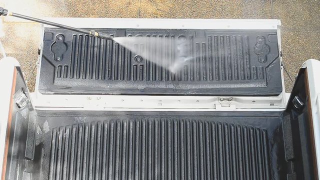 Car cleaning ,cleaning service concept.
Worker cleaning liner of pick up car with high pressure washer,HD slow motion.
