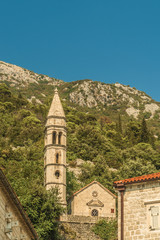 Fototapeta na wymiar View of old church in mediterranean city in croatia Perast in kotor bay, italian venetian architecture style and white bricks.