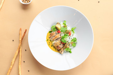 Grilled chicken breast in different variations with cherry tomatoes, green French beans, garlic, herbs, cut lemon on a wooden board or teflon pan. Traditional cuisine. Grill kitchen. white plate