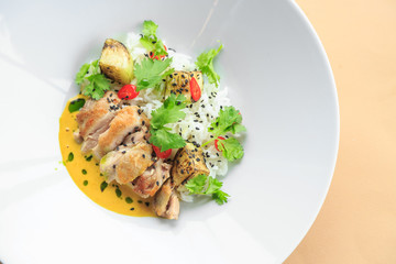 Grilled chicken breast in different variations with cherry tomatoes, green French beans, garlic, herbs, cut lemon on a wooden board or teflon pan. Traditional cuisine. Grill kitchen. white plate