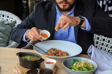 Man is eating in a restaurant and enjoying delicious food