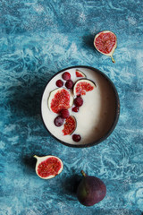 Overhead still life of smoothie bowl with fresh figs and cherry. Healthy vegetarian breakfast.