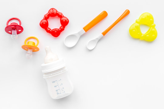preparation of mixture baby feeding with infant formula powdered milk in bottle with bib on white background top view mockup