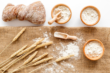 Production of wheat and rye flour from ear on white desk background top view