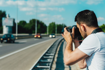 Man photographing cars on the road.