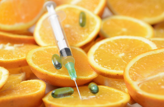 Extrayendo Vitamina C, con una Jeringa de una Naranja Cortada.