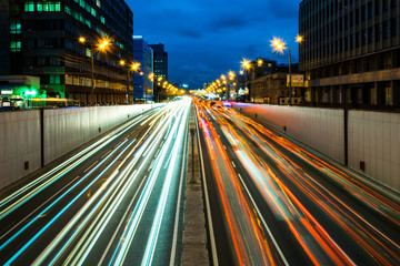 Fototapeta na wymiar Busy street in the city at dusk, full of car light streaks dynamic blue hour shot with long exposure