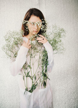 woman hide behind small white flowers