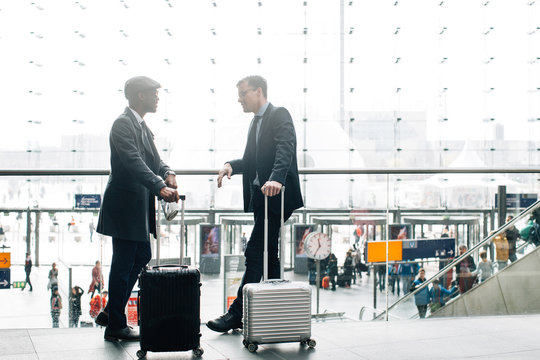 Two Business Travelers Chatting and Waiting in Bright Modern Glass Structure