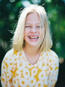 blonde girl laughing portrait in yellow floral dress