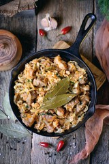 Stewed cabbage with pork in a cast-iron frying pan. Rustic style.