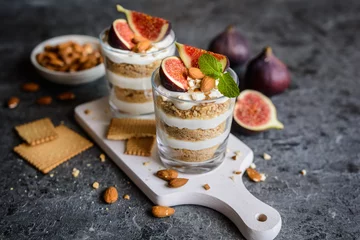 Foto op Plexiglas Dessert Gelaagd mascarponedessert met gemalen vanillekoekjes, vijgen en amandelen