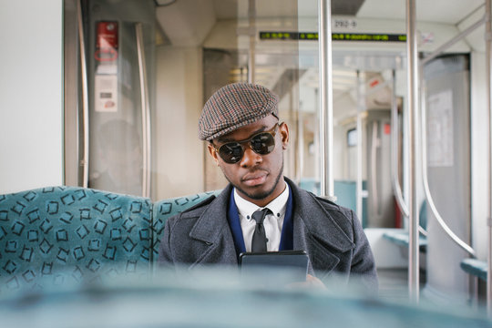 Portrait of Fashionable Black Businessman Reading Ebook in Train