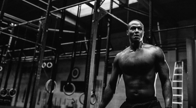 Young, fit black man training hard in fitness gym - post boxing