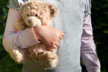 Lonely girl holding a teddy bear as of her best friend