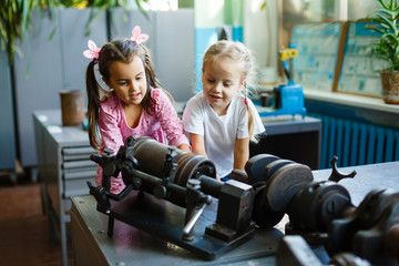 two happy little girls playing machine parts, playing with car parts.