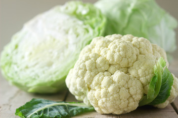 Cauliflower and cabbage on a wooden background. Rustic style, selective focus.