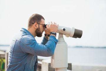 Fototapeta na wymiar Trendy male person look in binocular telescope