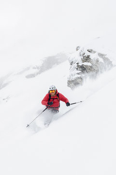 Skier taking a sharp turn splashing with snow
