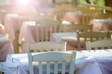 Tables and chairs in a street restaurant in Kamari on Santorini