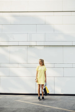 Blonde Woman Carrying Shopping Bags on the Street