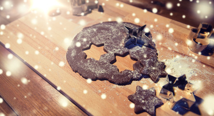 close up of ginger dough, molds and flour on board