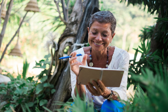 Senior Woman Writing a Journal on a Tropical Vacation