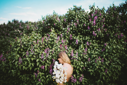 Back view of topless woman with lilac and orchid