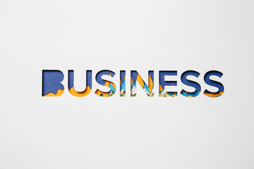 Business letters cut out of cardboard with graphs in the background