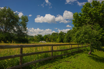 Fototapeta na wymiar wooden fence in a meadow in the village.