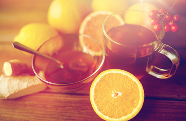 tea with honey, orange and rowanberry on wood