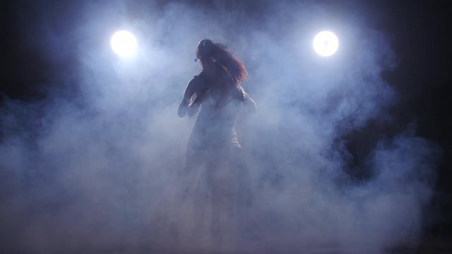 Beauty couple dancing bachata in dark room