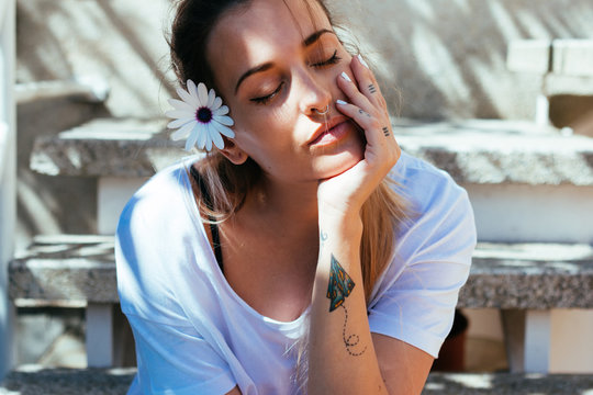 Portrait of relaxed woman with daisy in her hair