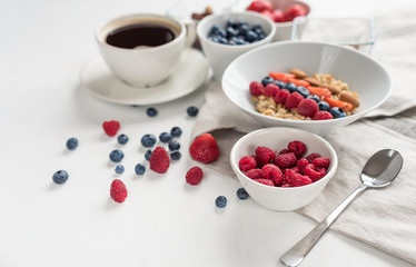 Good morning - healthy breakfast background with oatmeal coffee, berries, egg, nuts. White wooden food background,