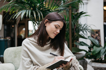Brunette writing in notebook
