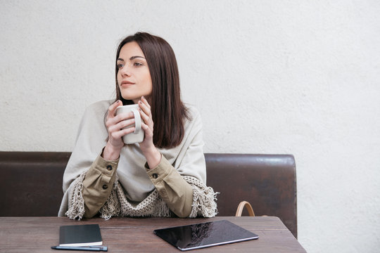 young woman using her tab/ digital notebook in a cafe