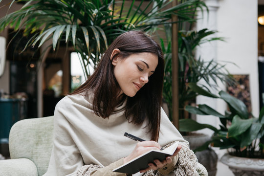 Brunette writing in notebook