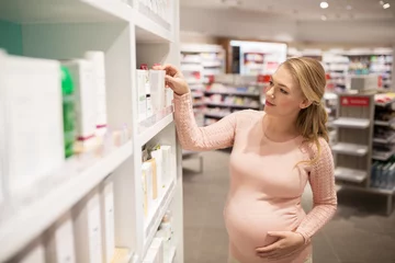 Foto op Canvas pregnant woman at pharmacy or cosmetics store © Syda Productions